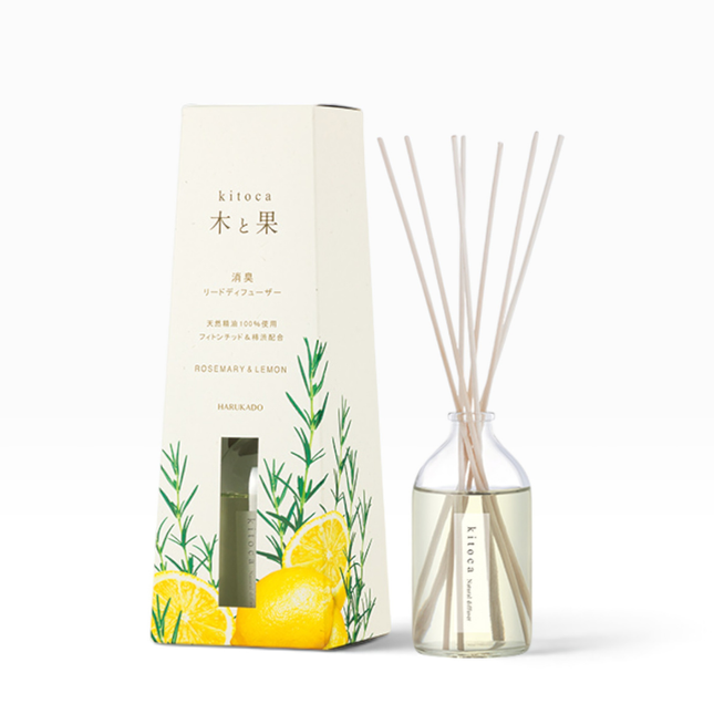 Kitoca reed diffuser set with a clear glass bottle, light beige reeds, and its cream-colored packaging box decorated with lemon and rosemary illustrations.