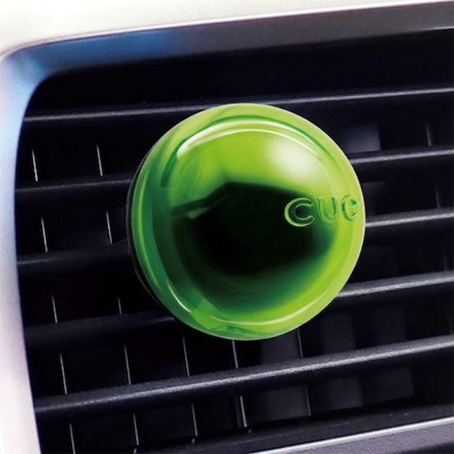 Green car air freshener on a car's air vent