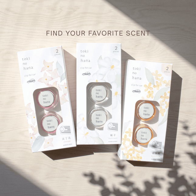 Three packages of 'toki nohana' car air fresheners on a light wooden surface.