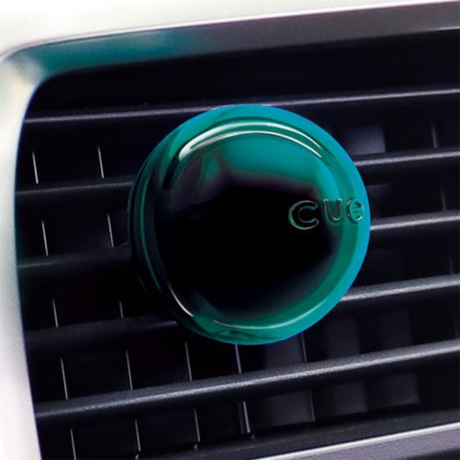 Green CUE car air freshener on a car's air vent