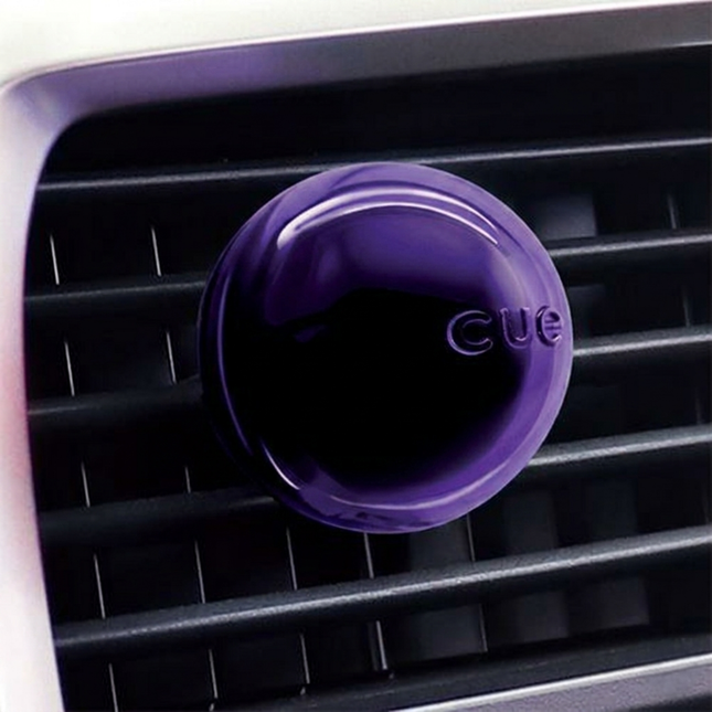 Purple CUE car air freshener on a car's air vent.